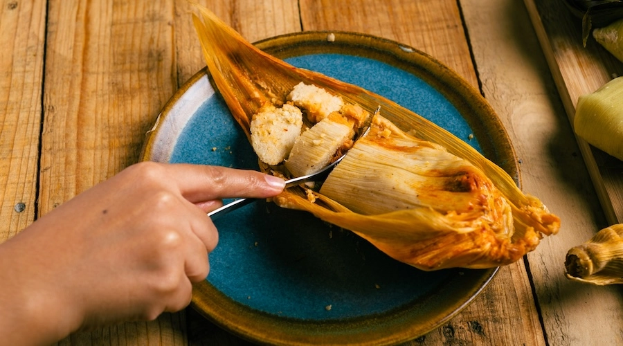 Person cutting a tamale