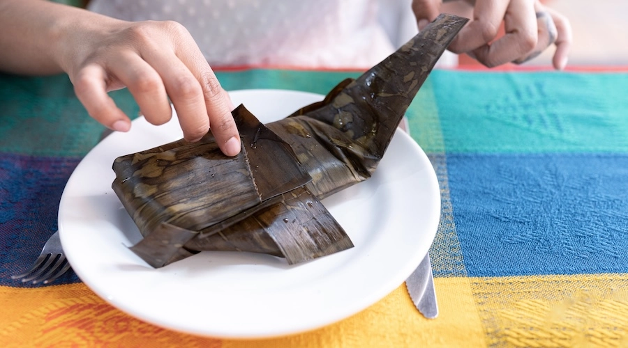 Woman is opening a meat tamale